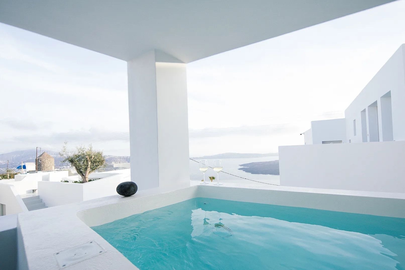 Kleine Pool-Wanne auf einer weißen Terrasse mit Aussicht auf das Meer.