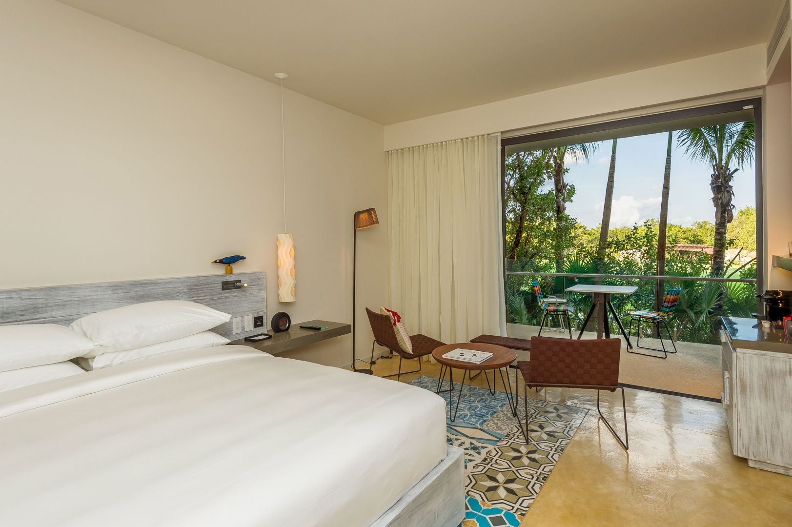 Gemütlicher Sitzbereich im Hotelzimmer mit Sesseln, Teppich und Blick nach draußen.