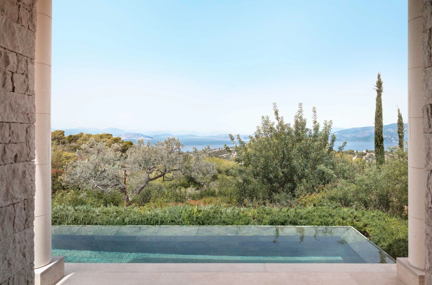 Infinitypool mit Blick auf eine mediterrane Pflanzenlandschaft und das Meer