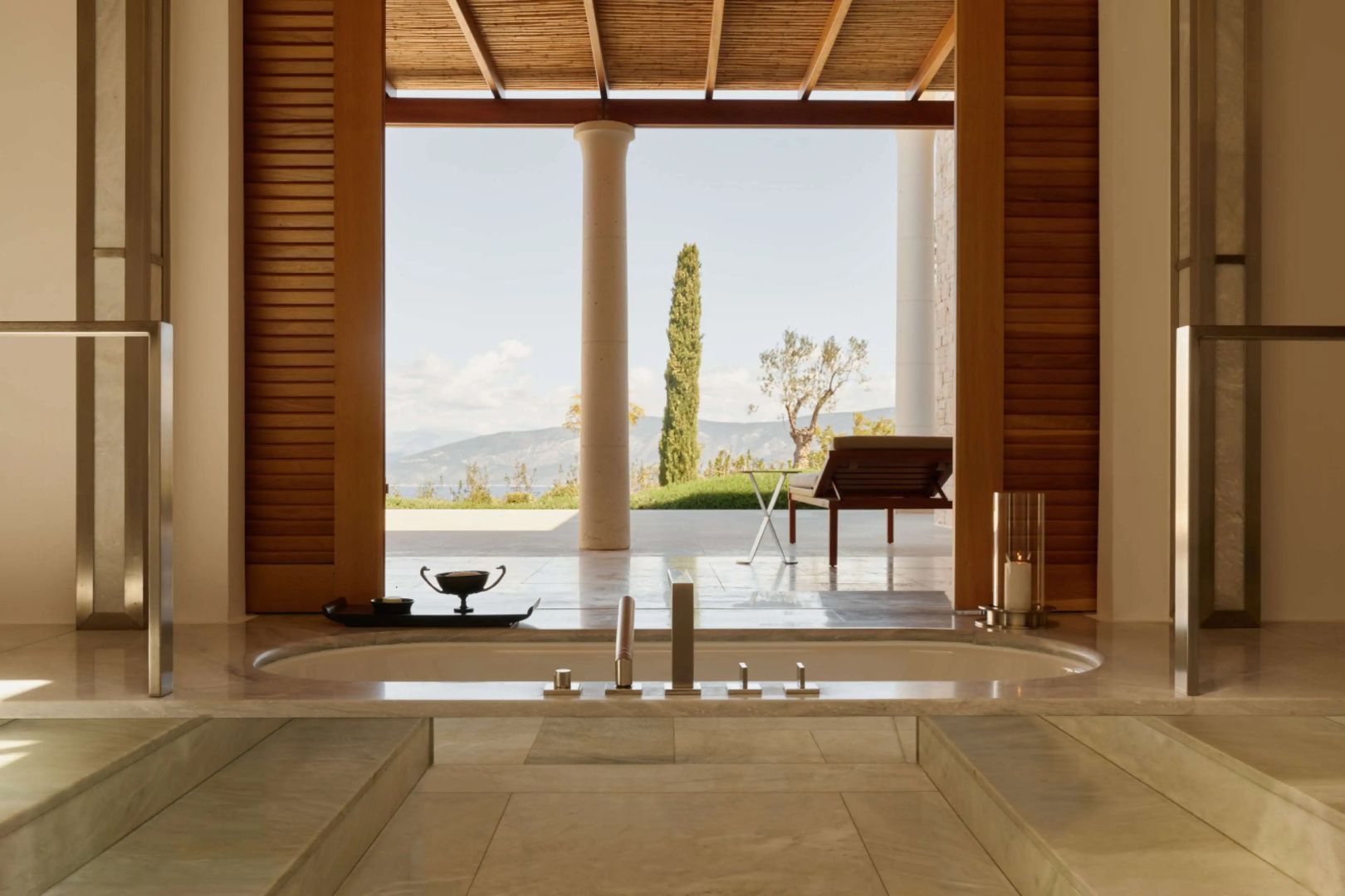 Eingelassene Badewanne mit Ausblick auf eine Terrasse und Natur