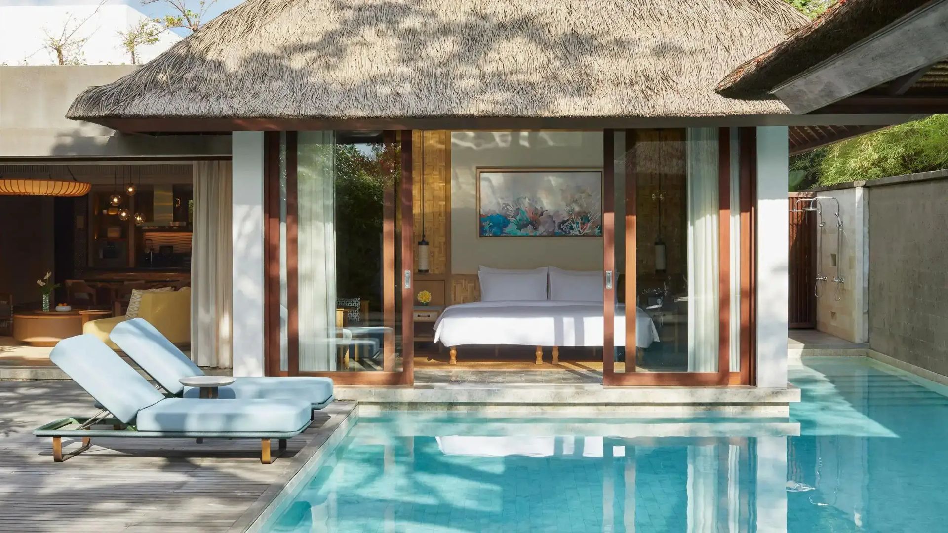 Schlafzimmer mit Doppelbett in einer Reetdach-Villa direkt am privaten Pool.