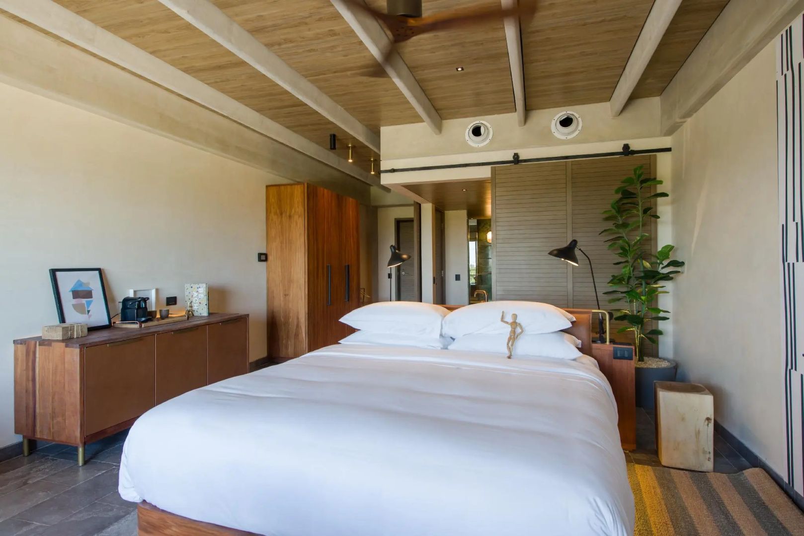 Modernes Hotelzimmer mit Doppelbett, Holzdecke und Deckenventilator.