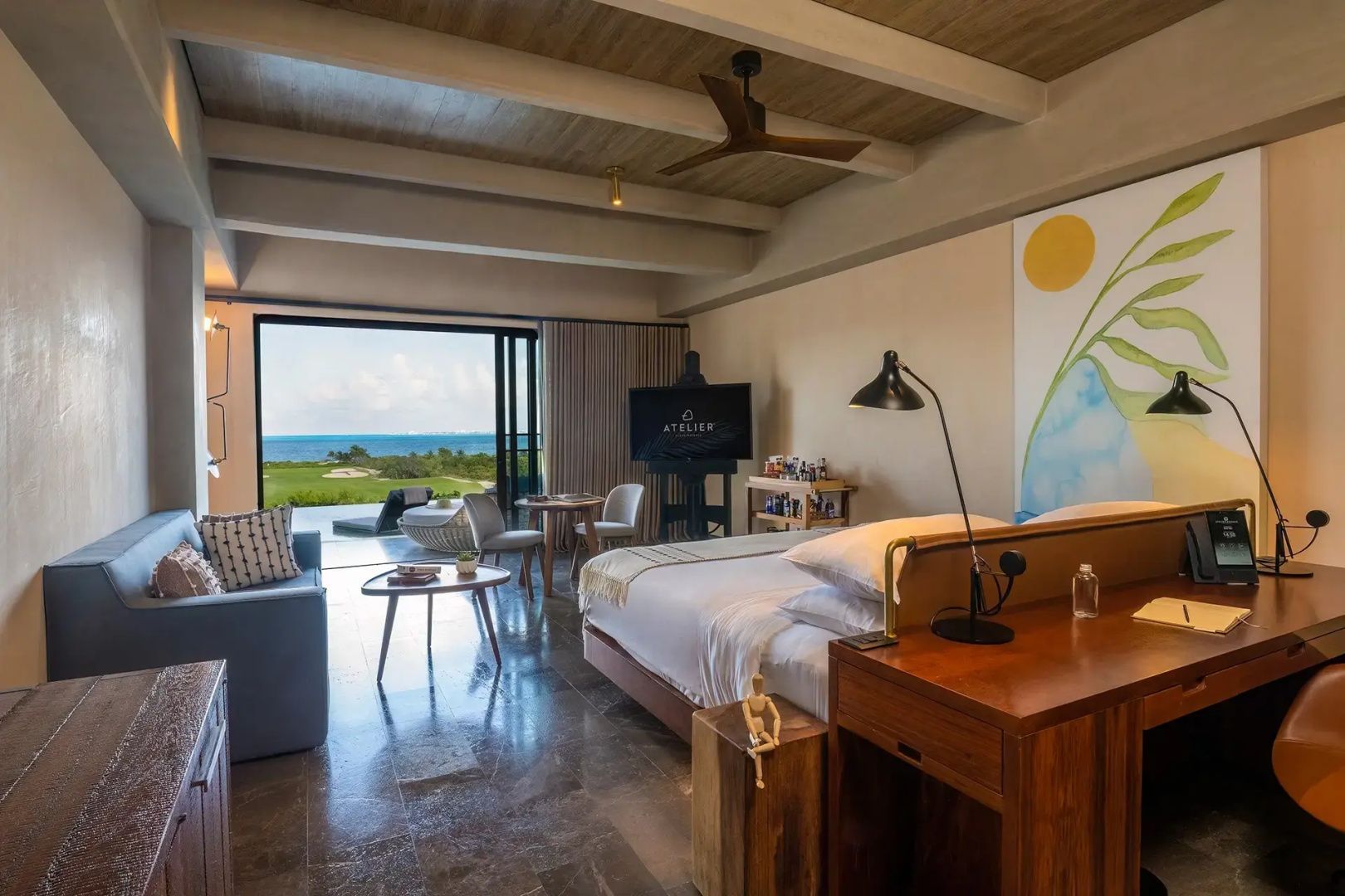 Geräumige Suite mit großem Bett, Sitzbereich und Zugang zur Terrasse mit Meerblick.