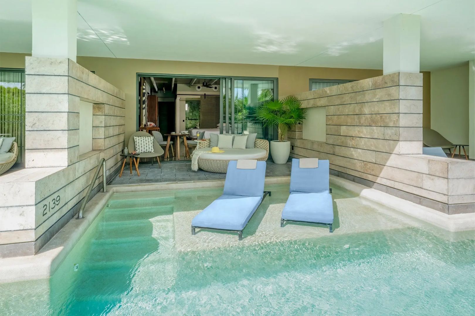 Private Terrasse mit kleinem Pool, zwei Sonnenliegen im Wasser und Sitzbereich.
