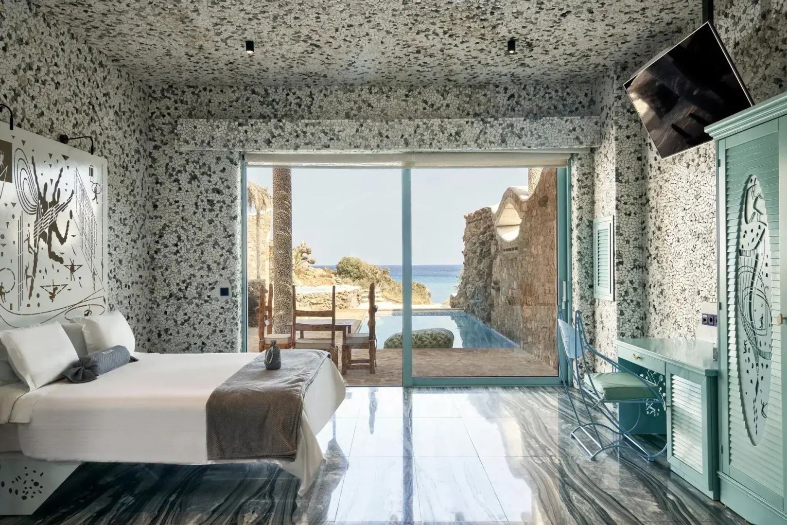 Blick aus dem Hotelzimmer über den privaten Pool und die Terrasse hinweg auf das blaue Meer.