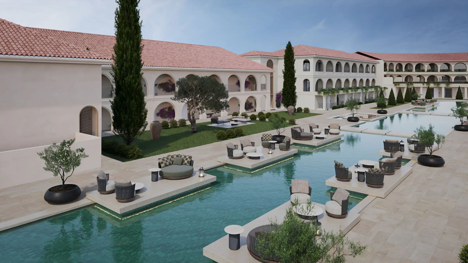 Große Poolanlage im Außenbereich mit Sitzinseln im Wasser und mediterraner Hotelarchitektur.