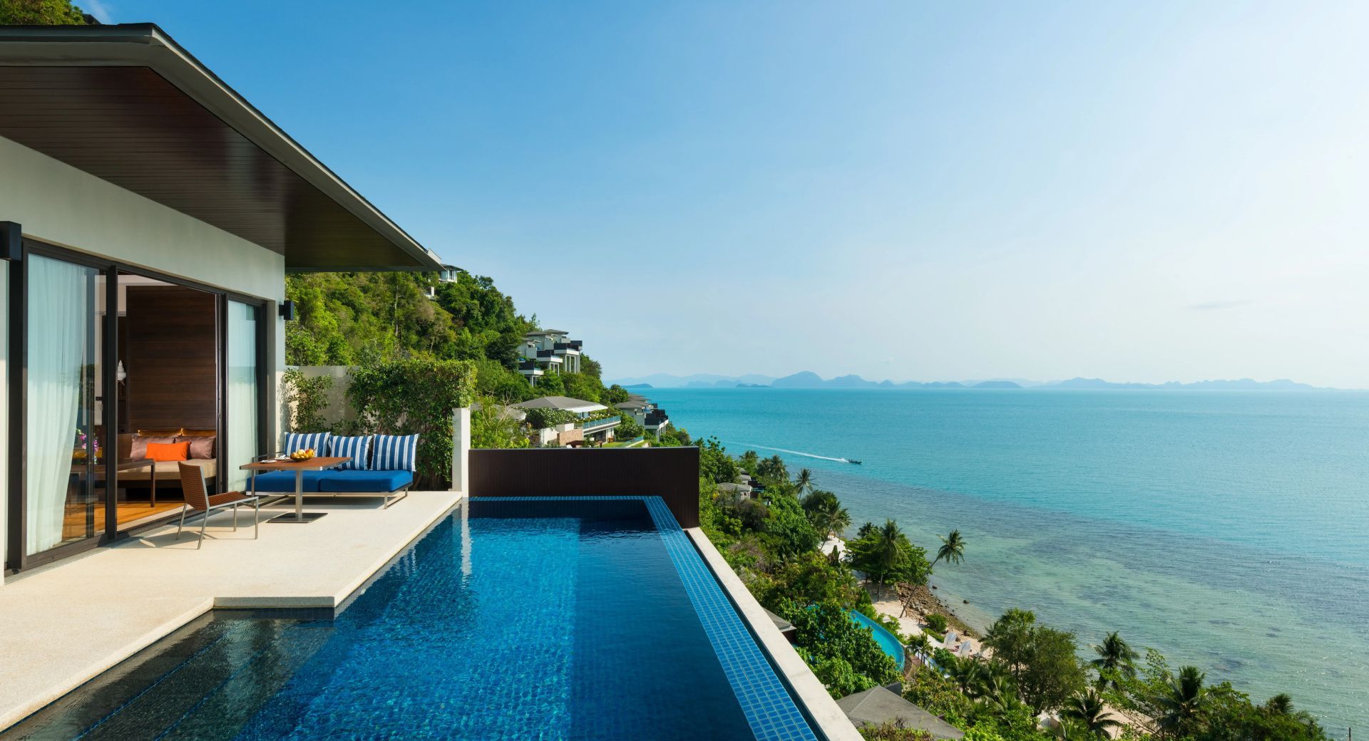 Pool auf einer Terrasse mit Blick auf das Meer und die bewaldete Küstenlandschaft.
