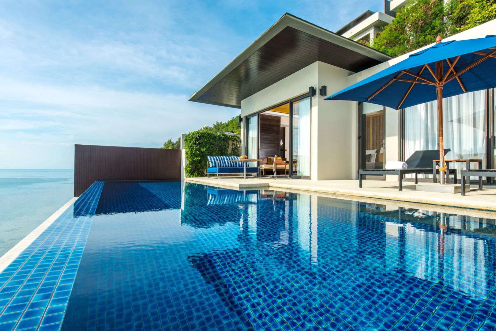 Moderne Villa mit privatem Pool auf der Terrasse und Blick auf den blauen Himmel.