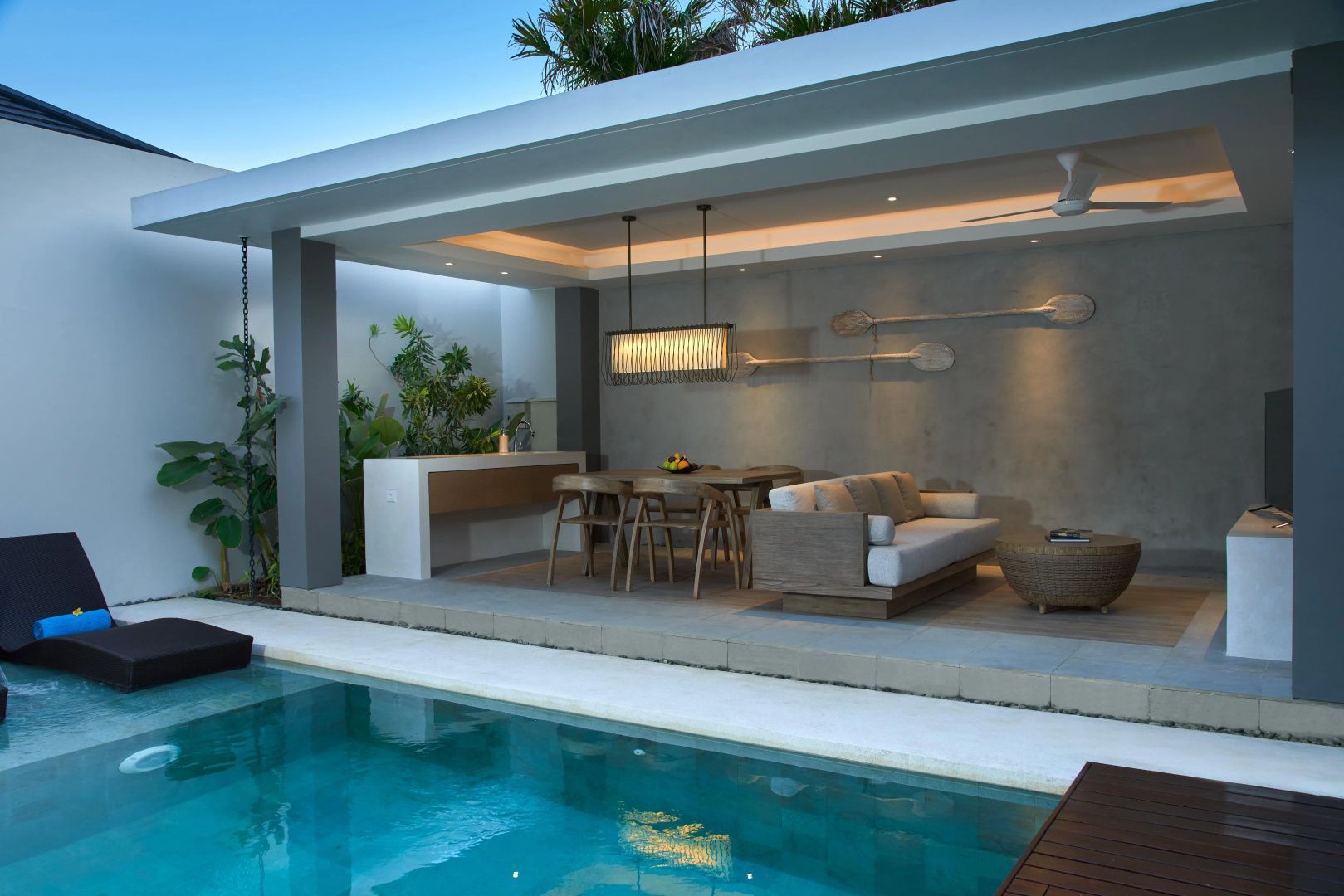 Überdachte Terrasse einer Villa mit Esstisch, Sofa und direktem Zugang zum privaten Pool.
