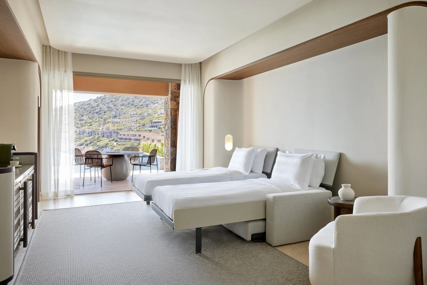 Helles Zimmer mit zwei Einzelbetten und Zugängen zur möblierten Terrasse.