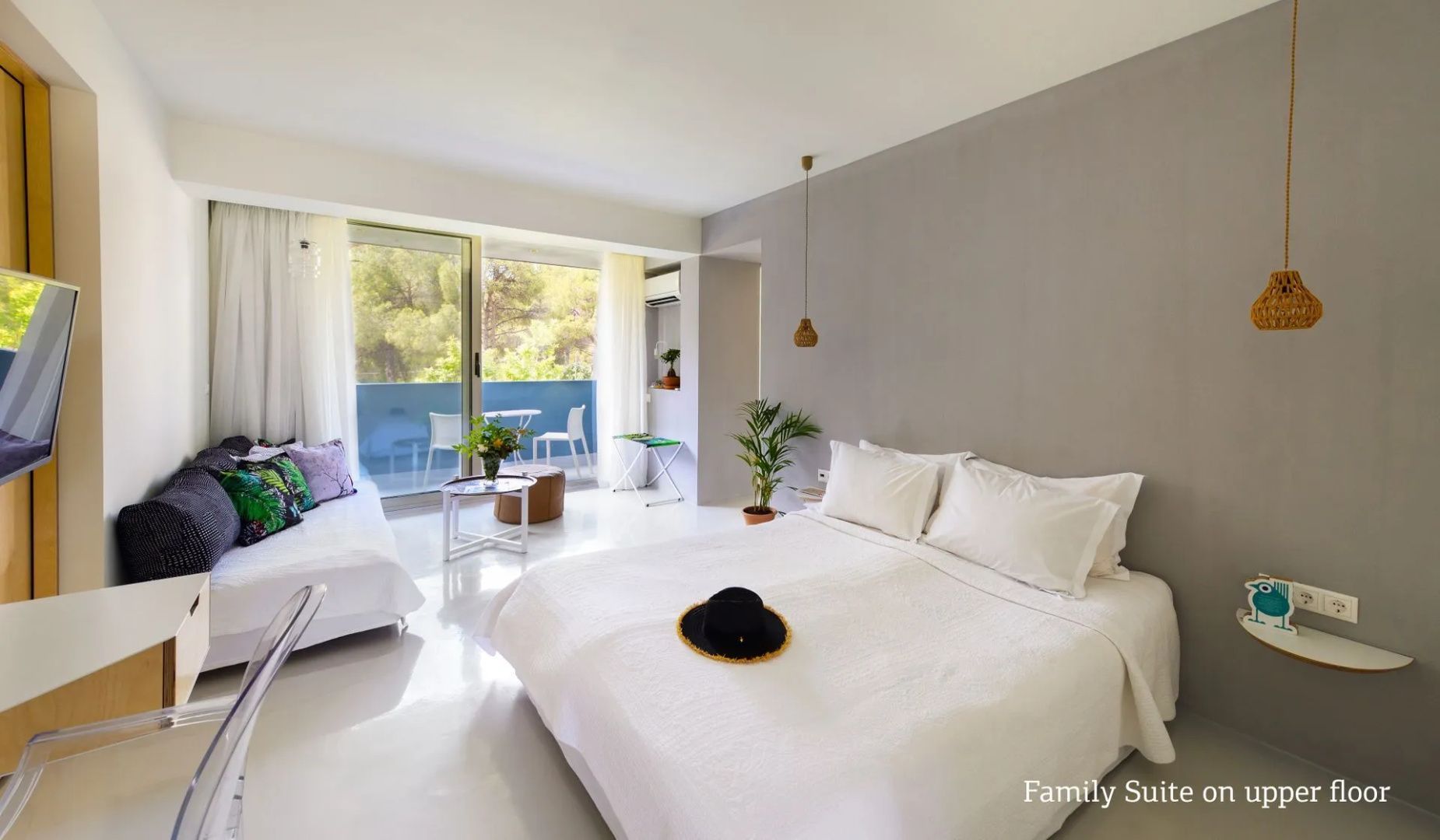 Geräumiges Schlafzimmer mit großem Doppelbett, Sitzecke und Balkonzugang.