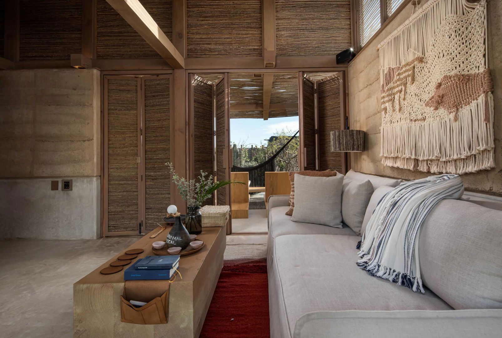 Wohnbereich mit hellem Sofa, Holztisch und Dekoration aus Naturmaterialien