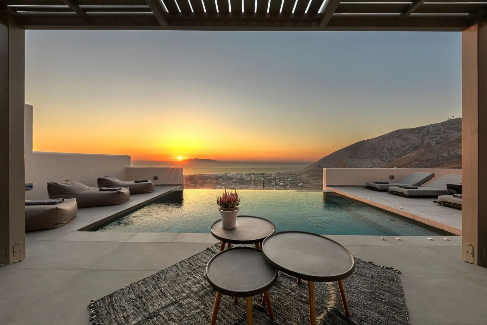 Terrasse mit Infinity-Pool und Blick auf den Sonnenuntergang über dem Meer.