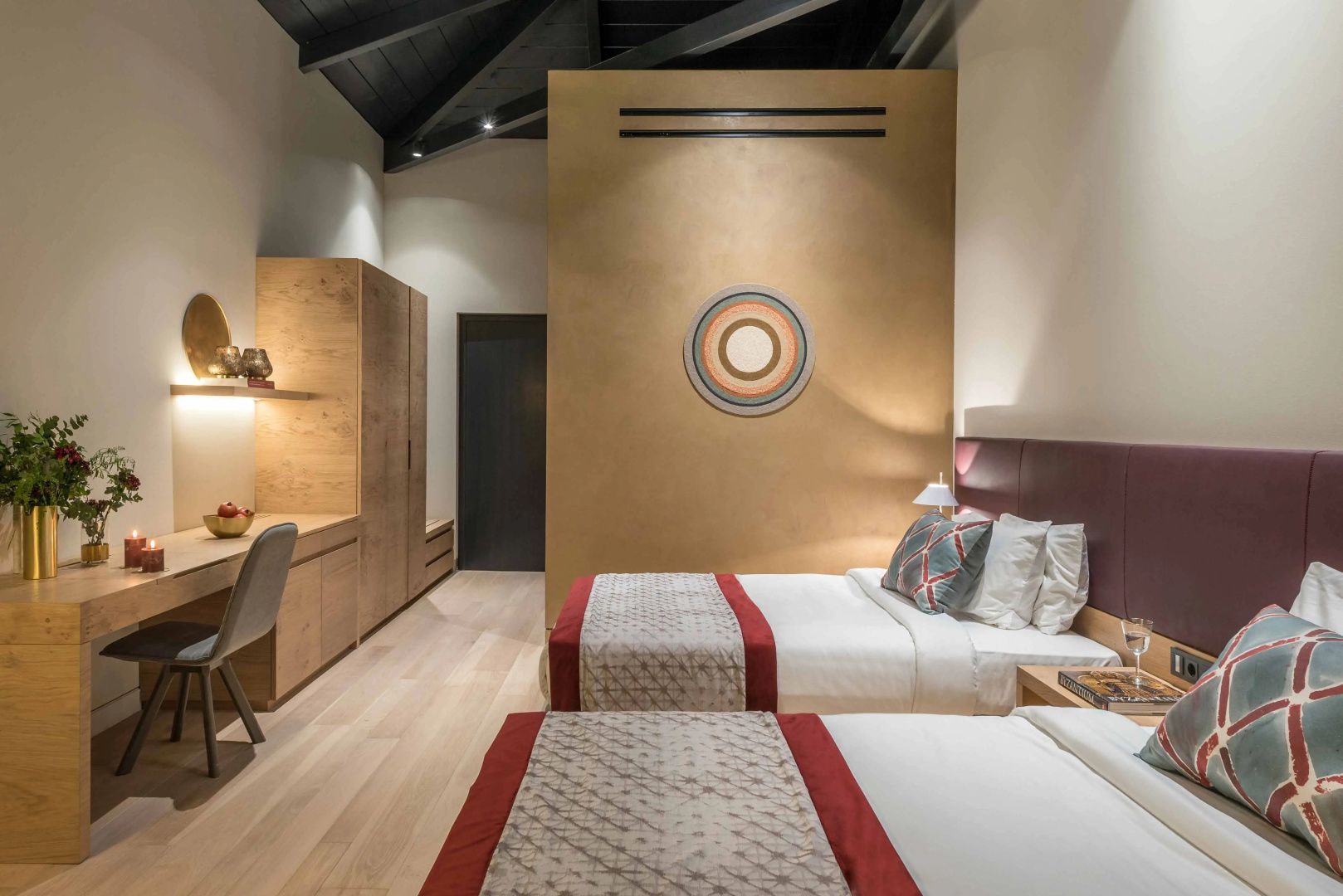 Hotelzimmer mit zwei Einzelbetten, Holzmöbeln und beige gestrichener Wand