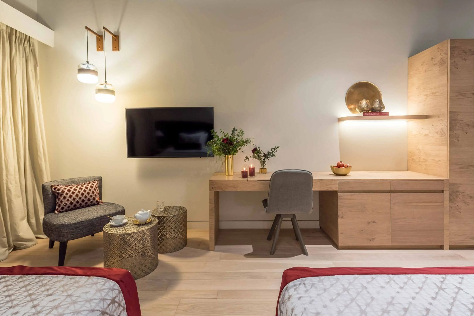 Schreibtisch mit Stuhl, Wand-TV und kleiner Sitzbereich mit Teegeschirr im Zimmer