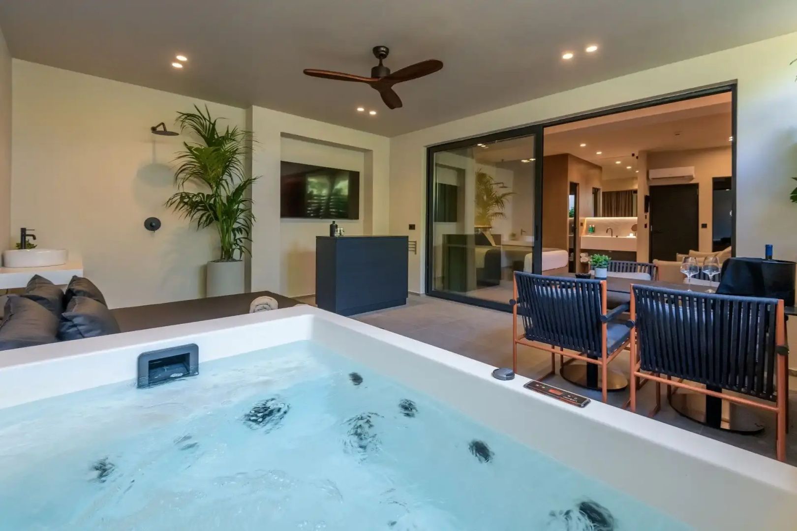 Whirlpool auf einer privaten Terrasse mit Sitzgelegenheiten und Zugang zum Zimmer.