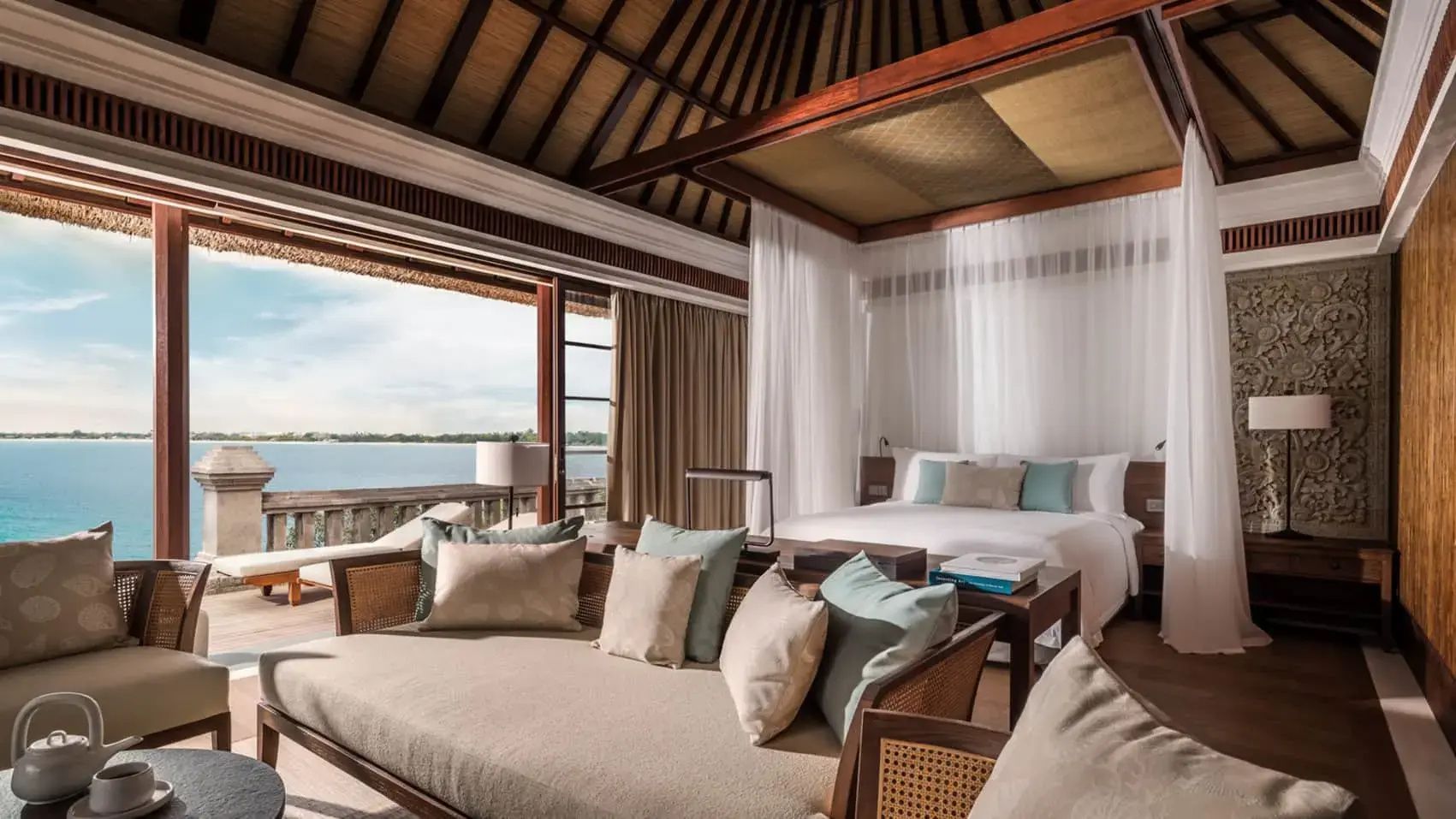 Geräumiges Schlafzimmer in einer Villa mit Holzdecke, großem Bett und Blick auf das Meer.