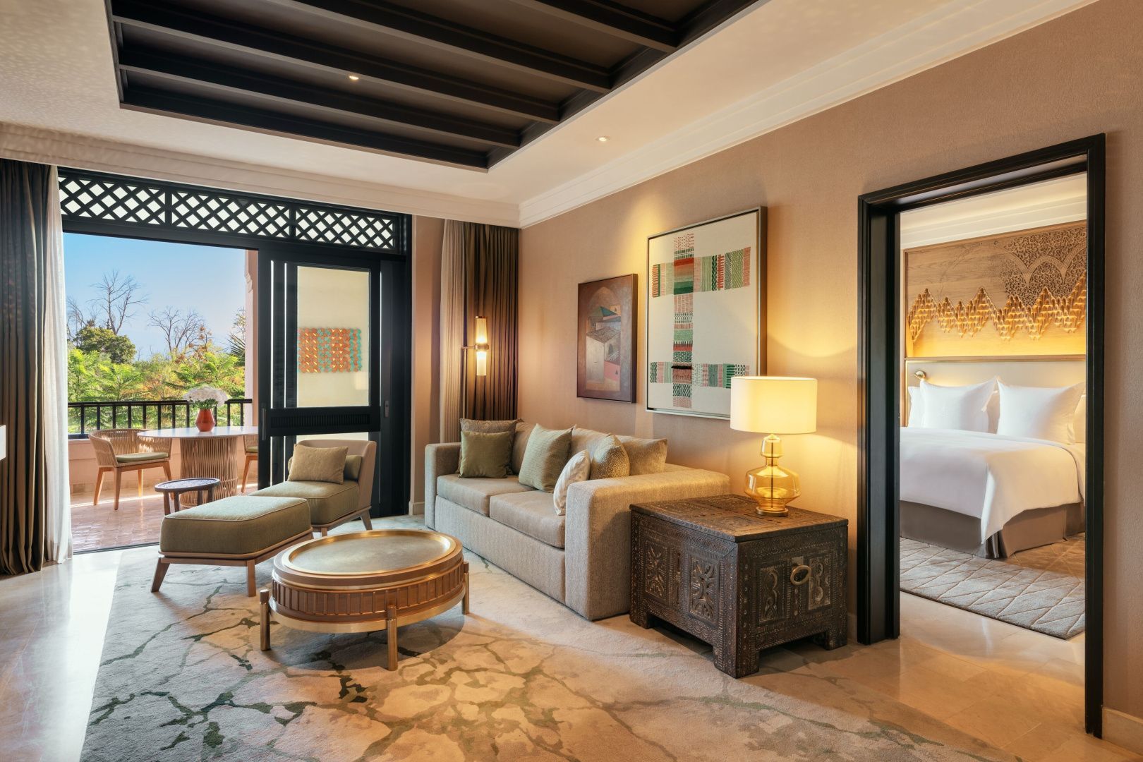 Wohnzimmer einer Suite mit Blick zum Balkon und Durchgang zum Schlafzimmer.