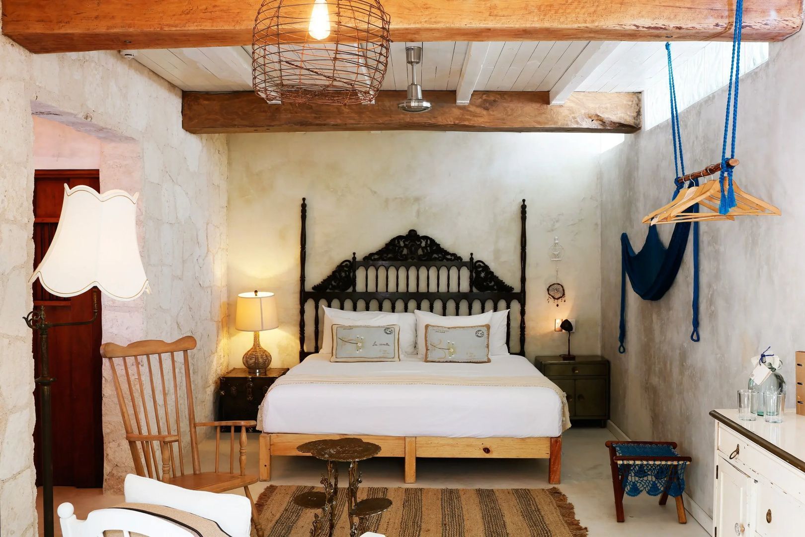 Schlafzimmer mit einem verzierten Holzkopfteil am Bett und Holzdecke.
