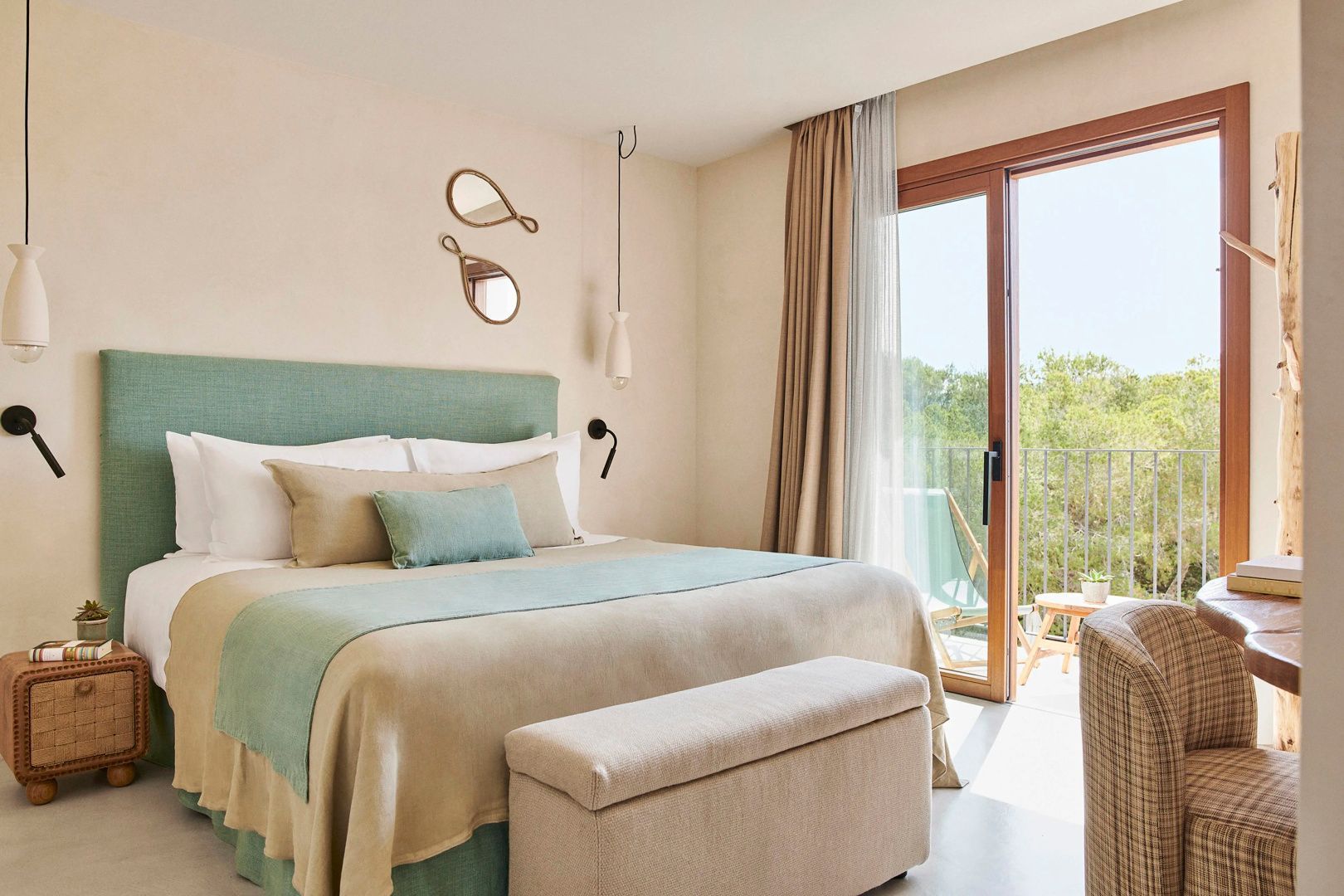 Hell eingerichtetes Schlafzimmer mit beige-grünem Doppelbett und Balkontür.