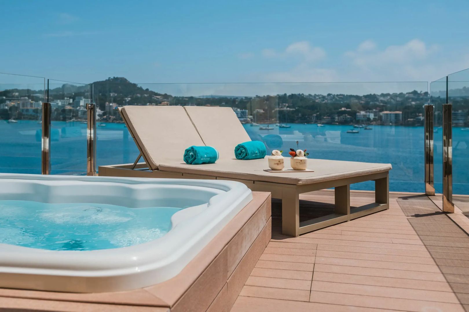 Whirlpool und Sonnenliege auf einer Terrasse mit freiem Blick auf das Meer.