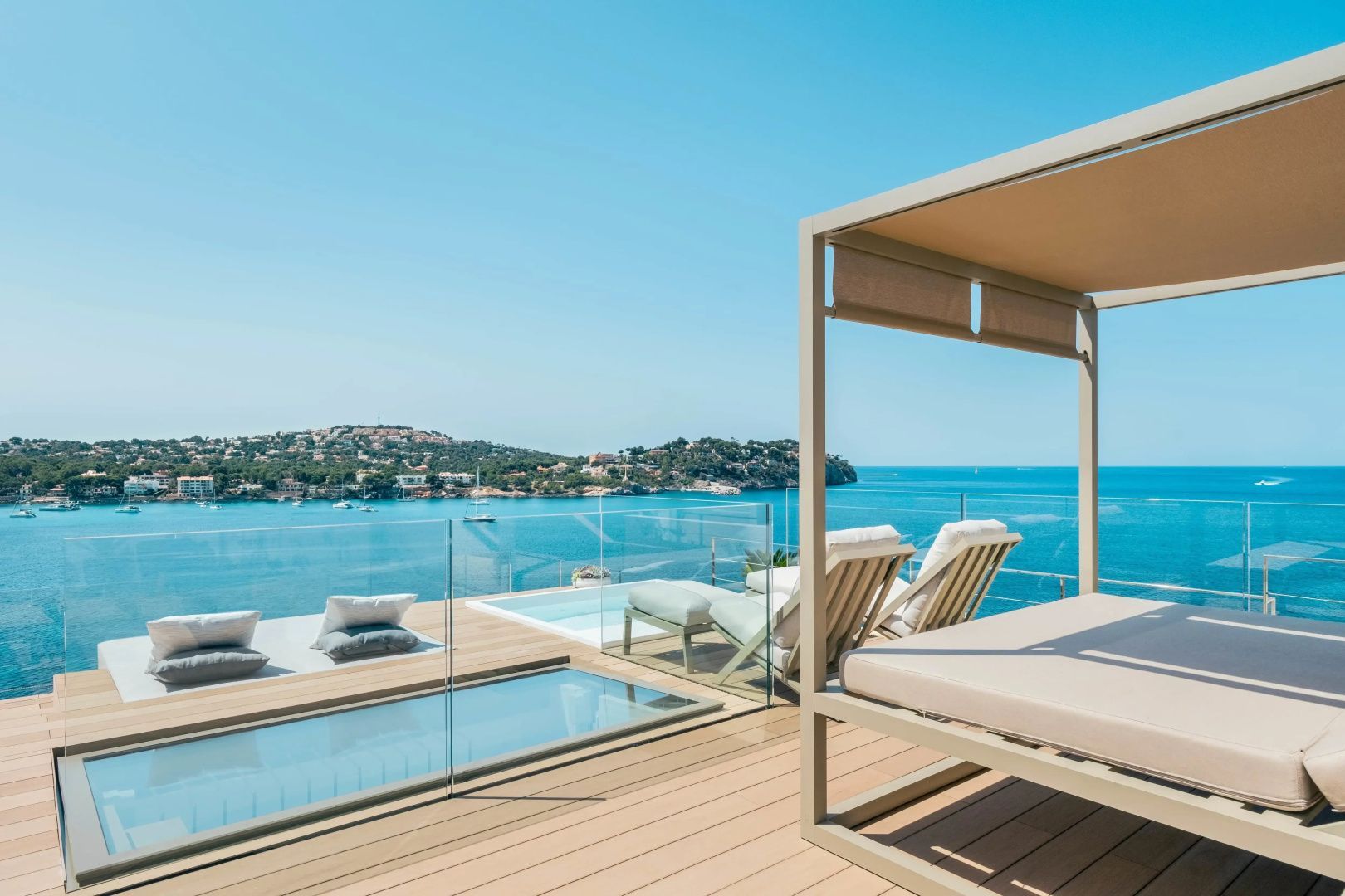Dachterrasse mit Pavillon und Sonnenliegen mit Panoramablick auf die Meeresbucht.
