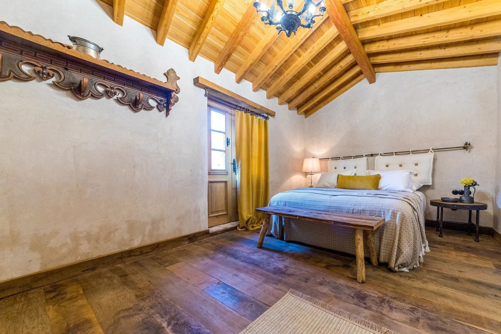 Schlafzimmer unter der Dachschräge mit Holzboden und Doppelbett.