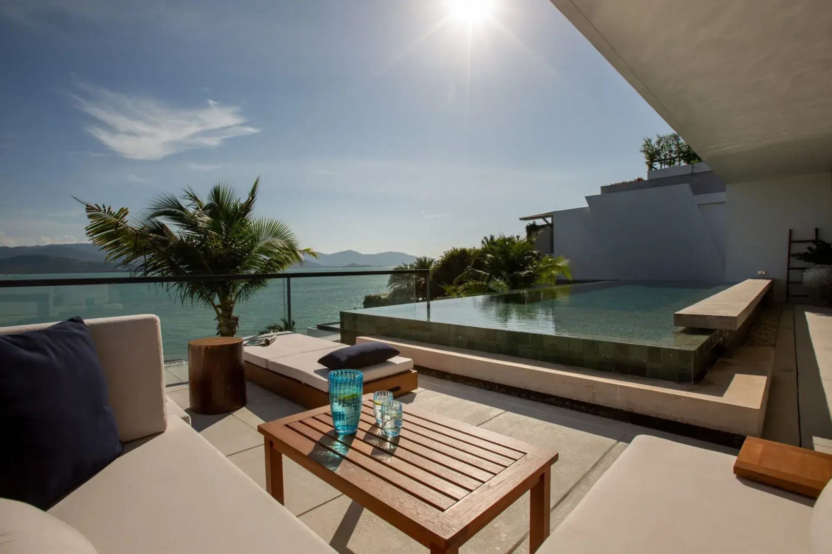 Terrasse mit privatem Pool, Sonnenliegen und Panoramaaussicht auf das Meer.