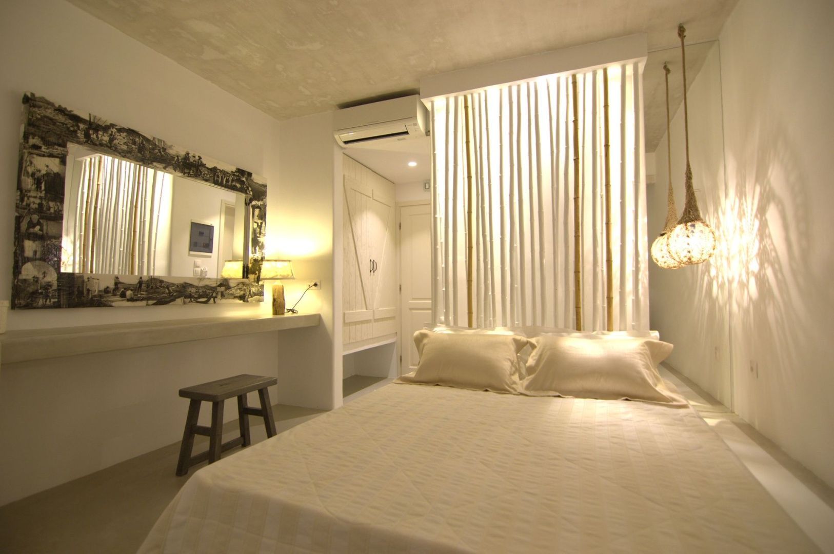 Hotelzimmer mit Doppelbett, Spiegel und dekorativem Holzelement.