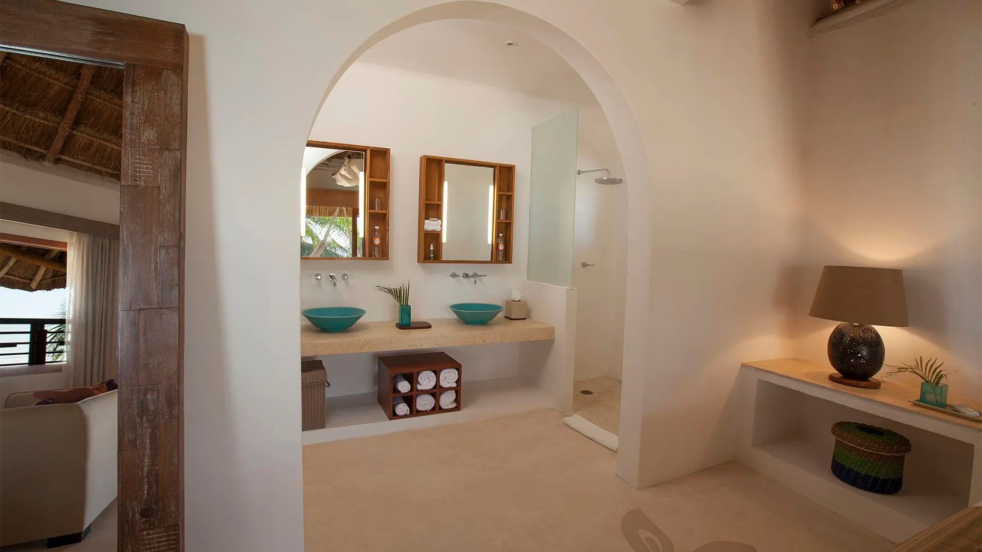 Badezimmer mit zwei blauen Aufsatzwaschbecken, Spiegeln und einer begehbaren Dusche.