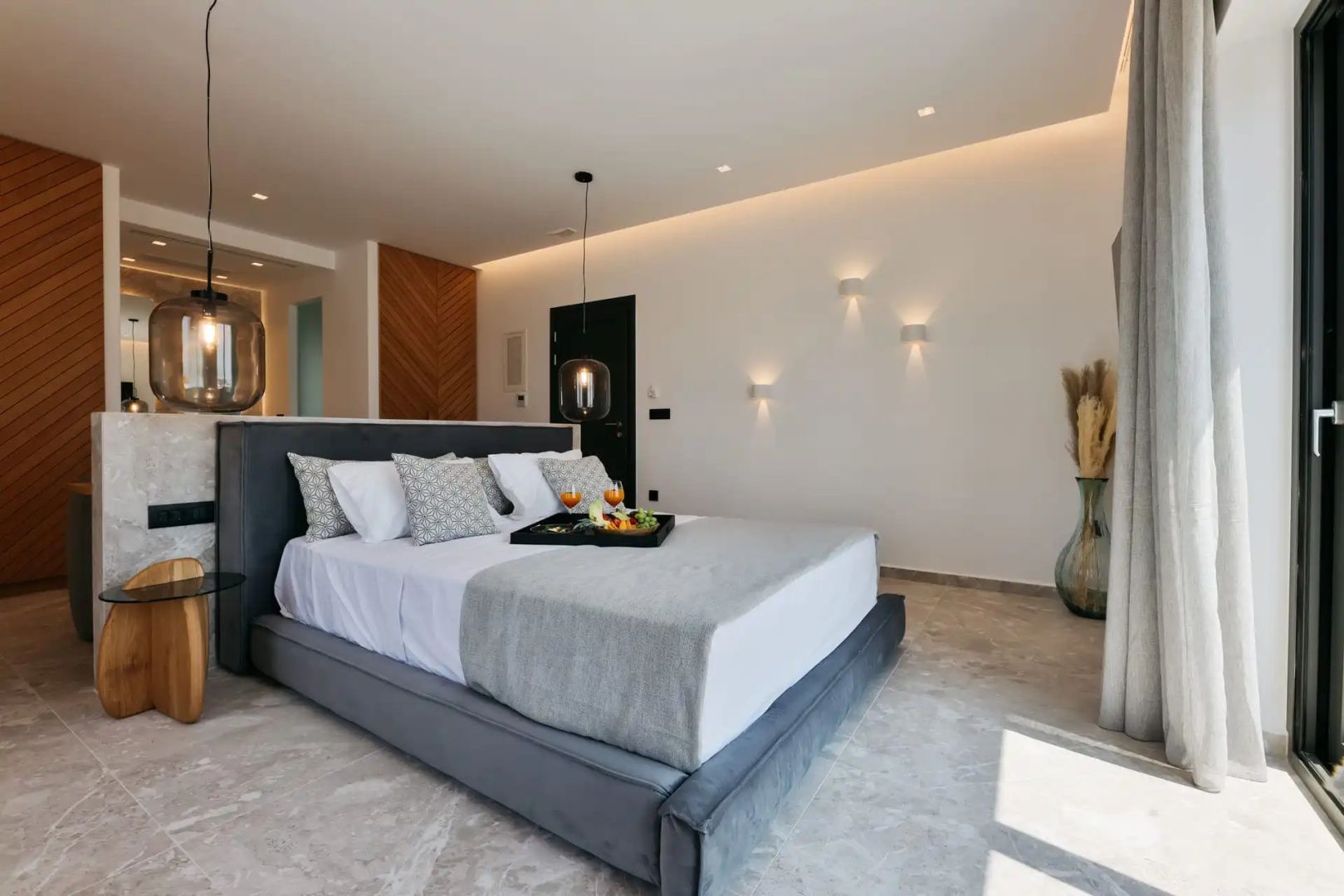 Modernes Hotelzimmer mit Doppelbett, grauer Kopfstütze und weißer Bettwäsche.