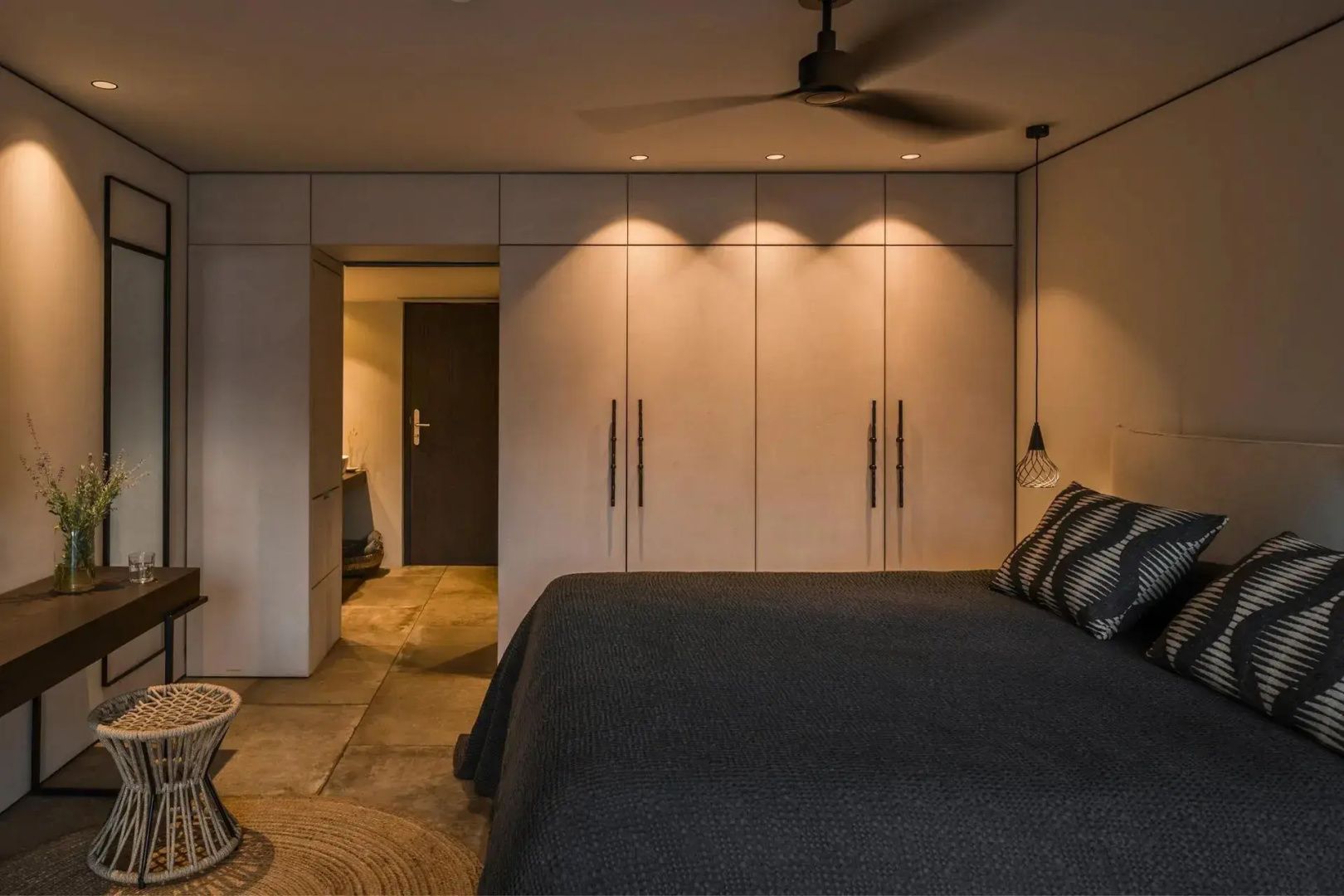 Hotelzimmer mit Doppelbett, Wandschrank mit Beleuchtung und Durchgang zum Badezimmer