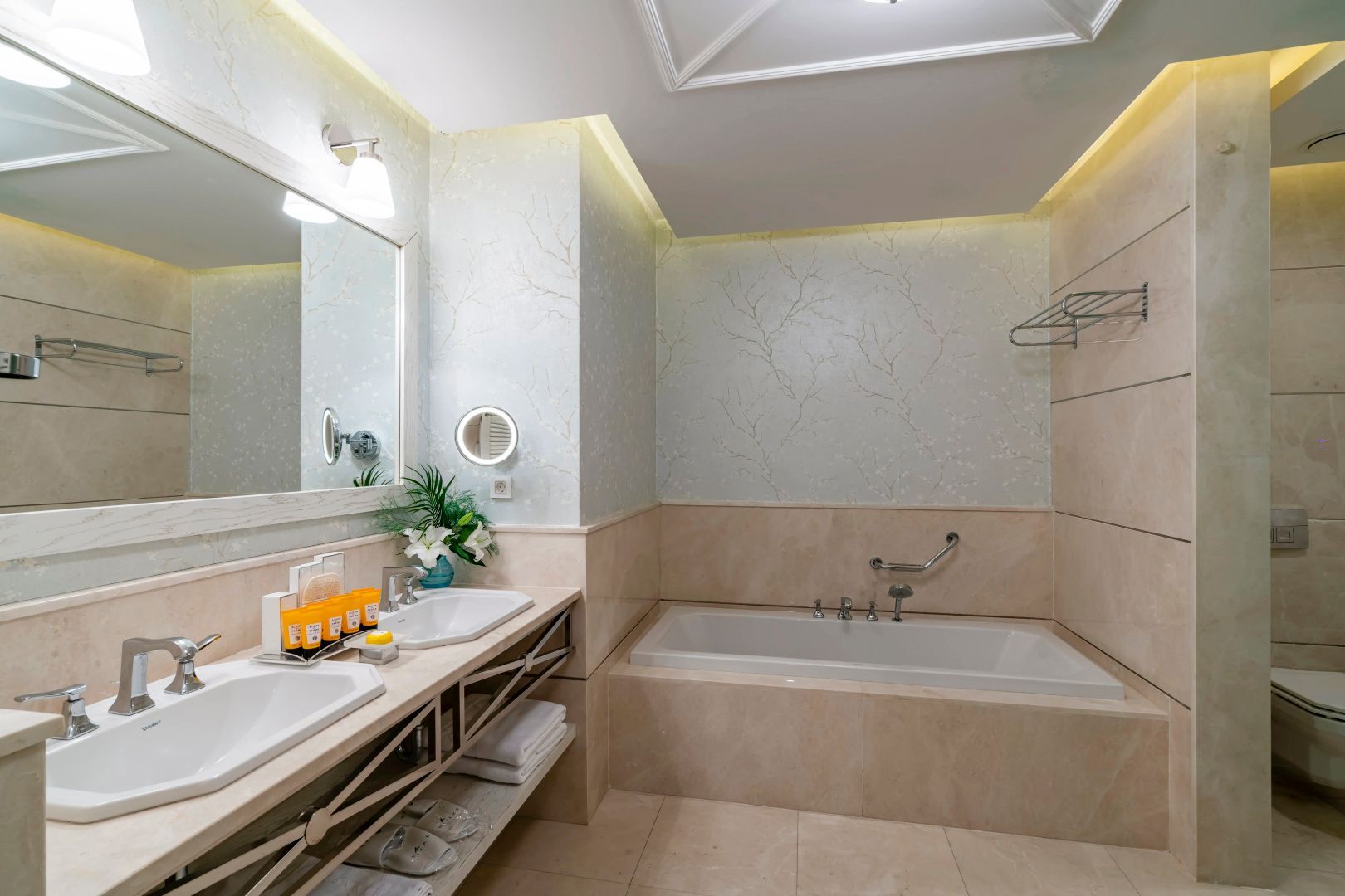 Helles Badezimmer mit eingebauter Badewanne, großem Waschtisch und Wandspiegel.