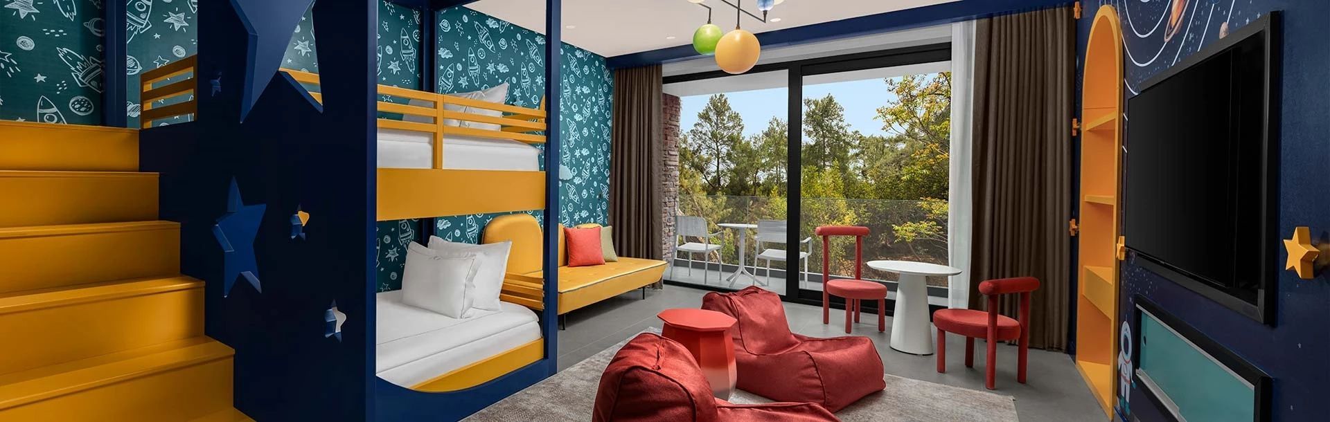 Kinderzimmer mit gelbem Sofa, Etagenbett und Balkonfenster mit Blick ins Grüne.