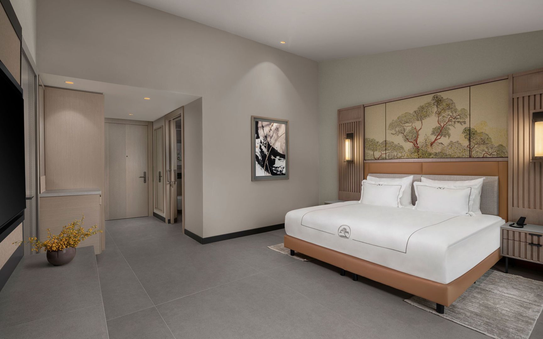 Schlafzimmer eines Hotelzimmers mit großem Doppelbett und Flurbereich.