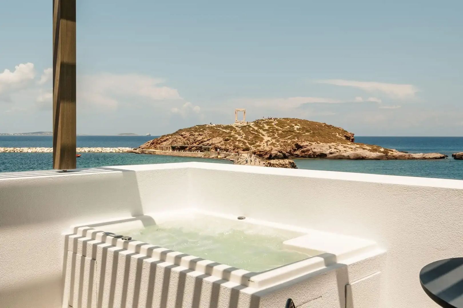 Whirlpool auf der Terrasse mit Blick auf das Meer und ein historisches Monument.