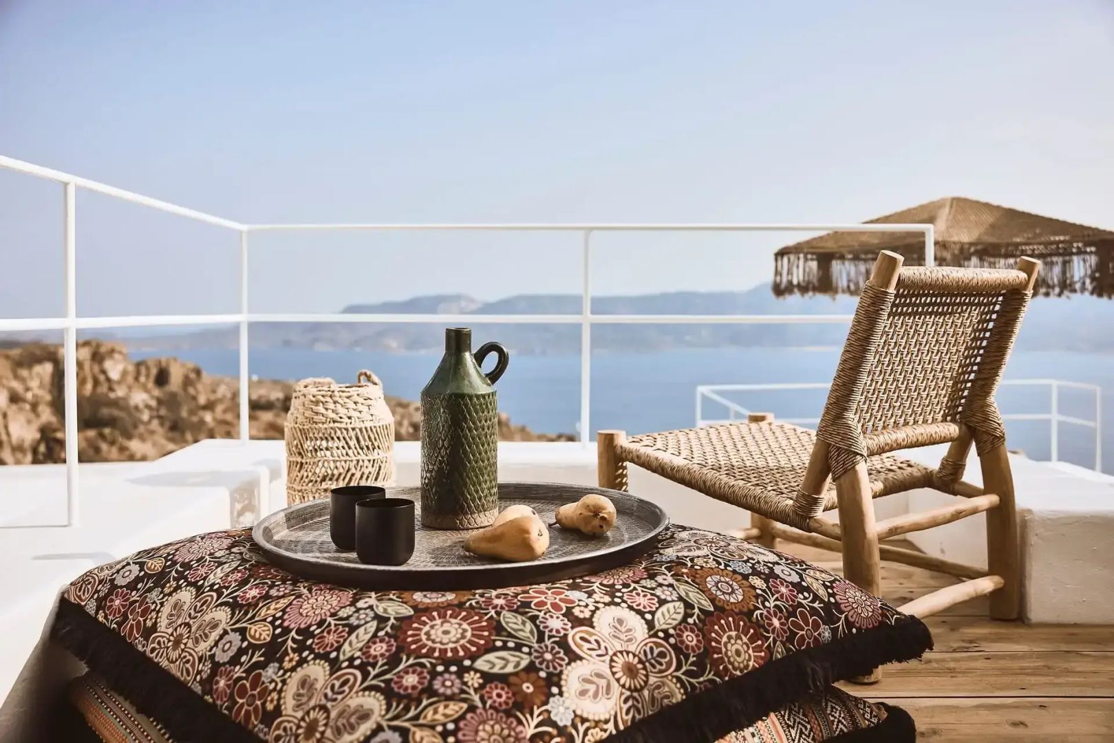 Bedrucktes Sitzkissen und Tablett auf der Terrasse mit weitem Blick über die Meeresbucht.