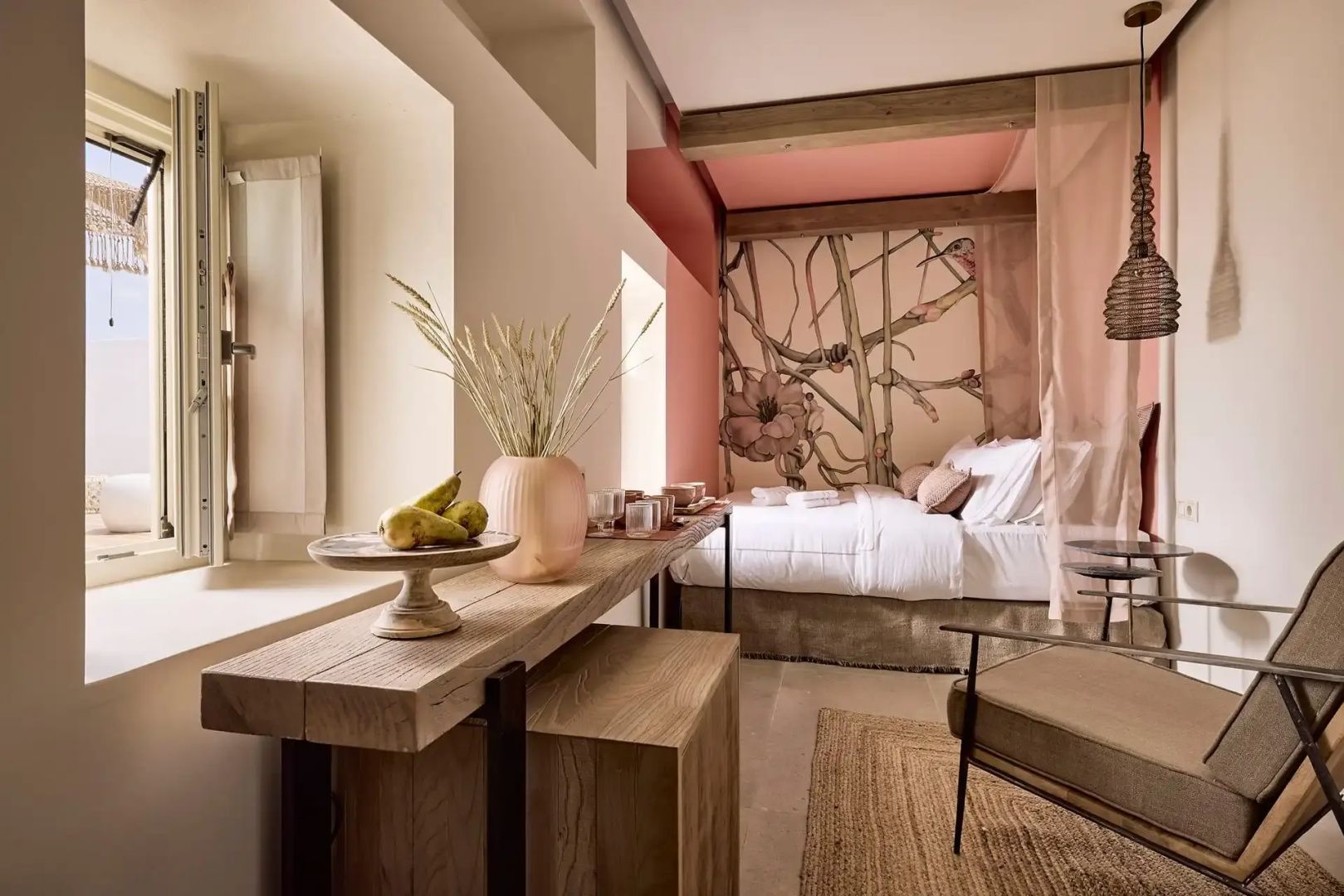 Schlafbereich mit Holzkonsole, dekorativer Vase und Wandbild hinter dem Bett.