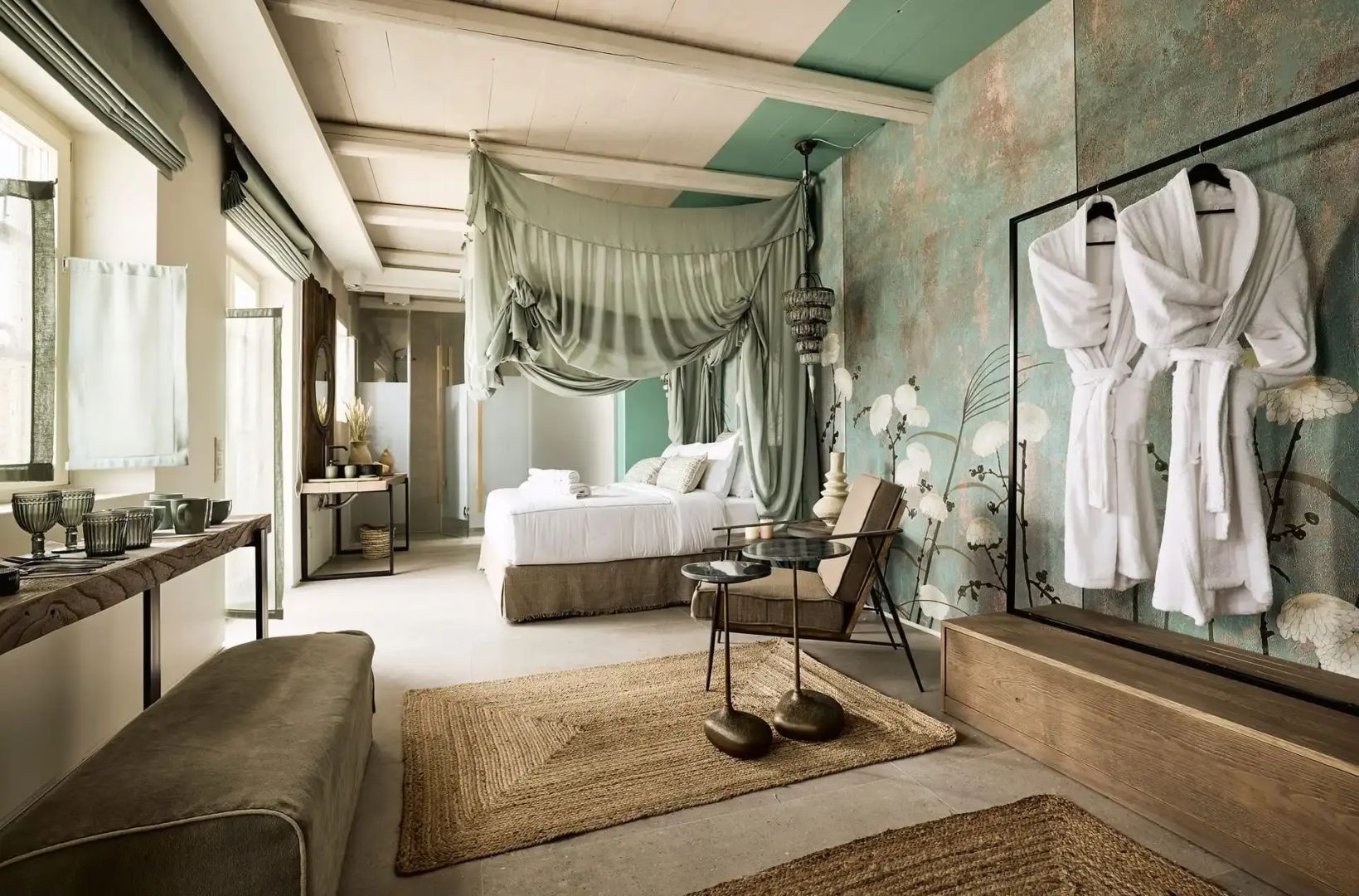 Geräumiges Schlafzimmer mit Baldachinbett, Sitzgruppe und bemalter Wandgestaltung.