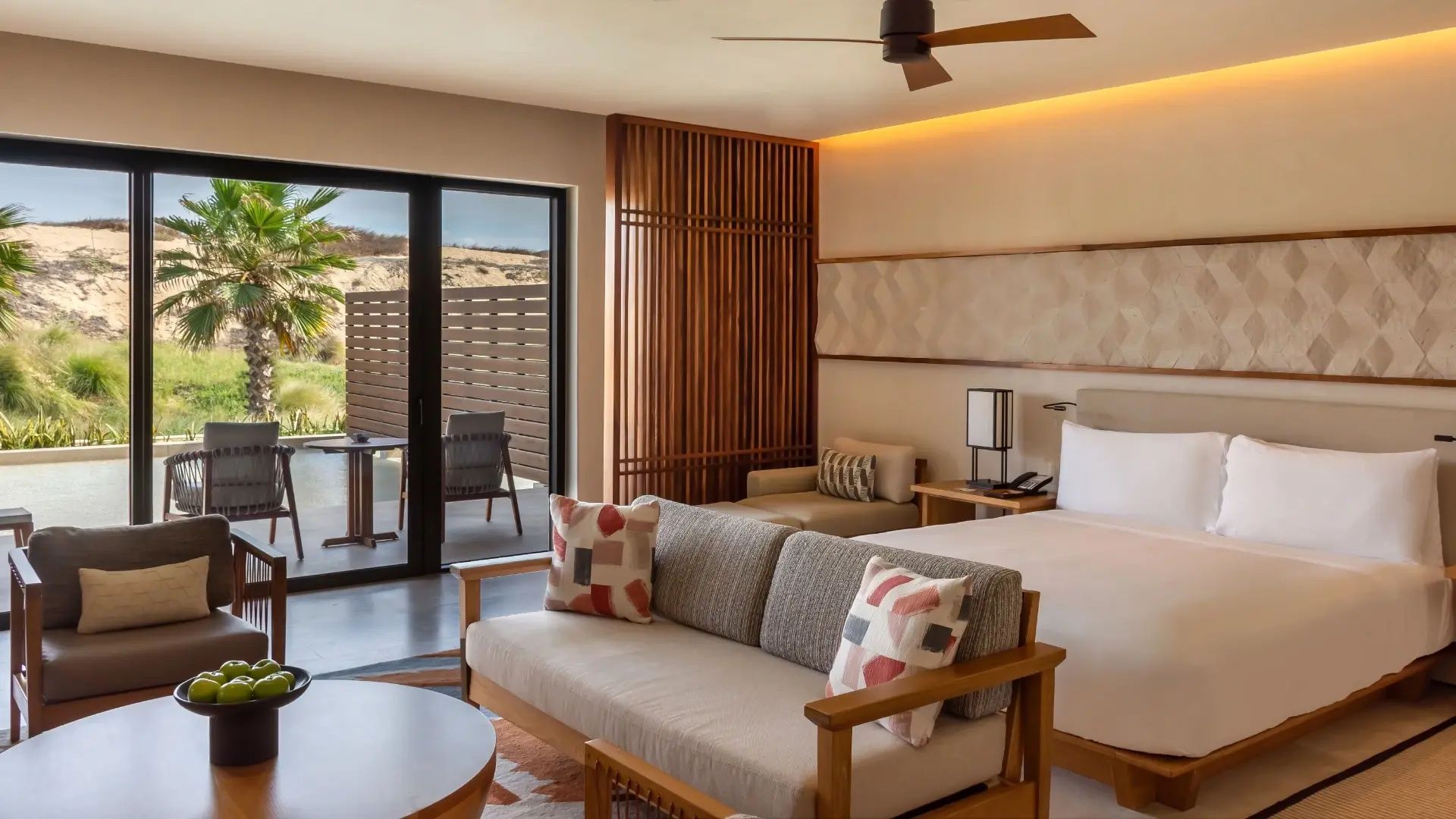 Sitzbereich in der Suite mit modernem Sofa und Zugang zur privaten Terrasse.