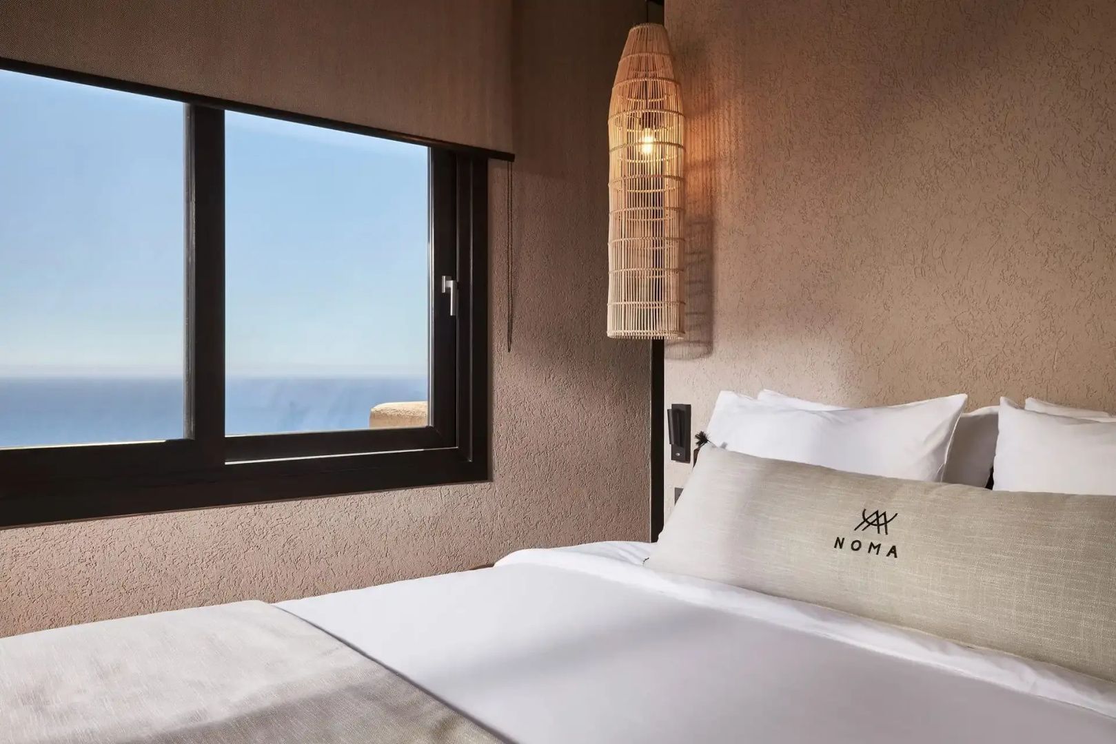 Doppelbett an einem Fenster mit direktem Blick auf das offene Meer.