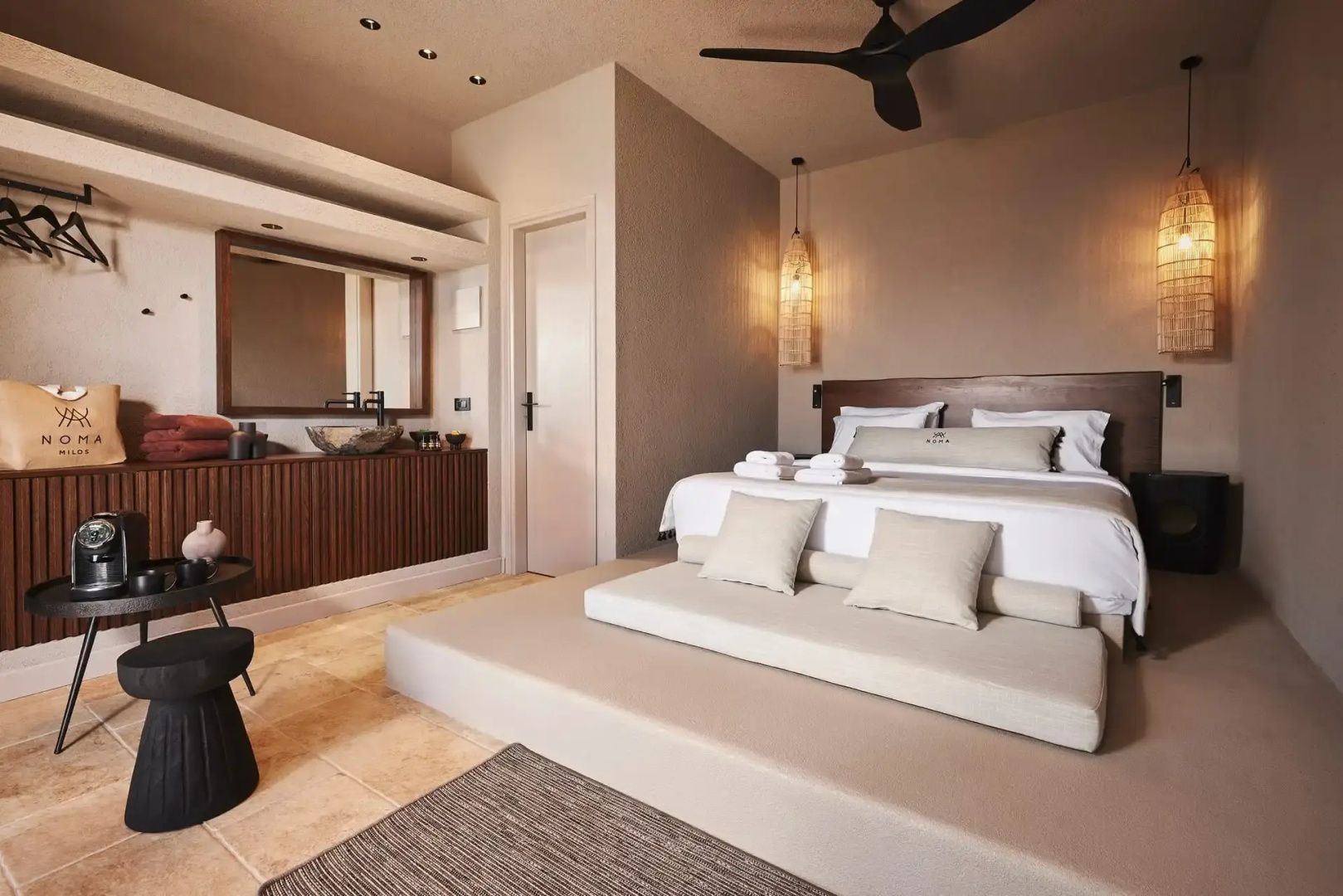 Geräumiges Hotelzimmer mit einem Doppelbett, Deckenventilator und Waschtisch.