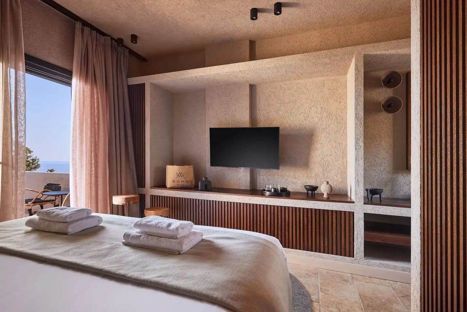 Wandmontierter Flachbildfernseher über einem Holzschrank im Hotelzimmer.