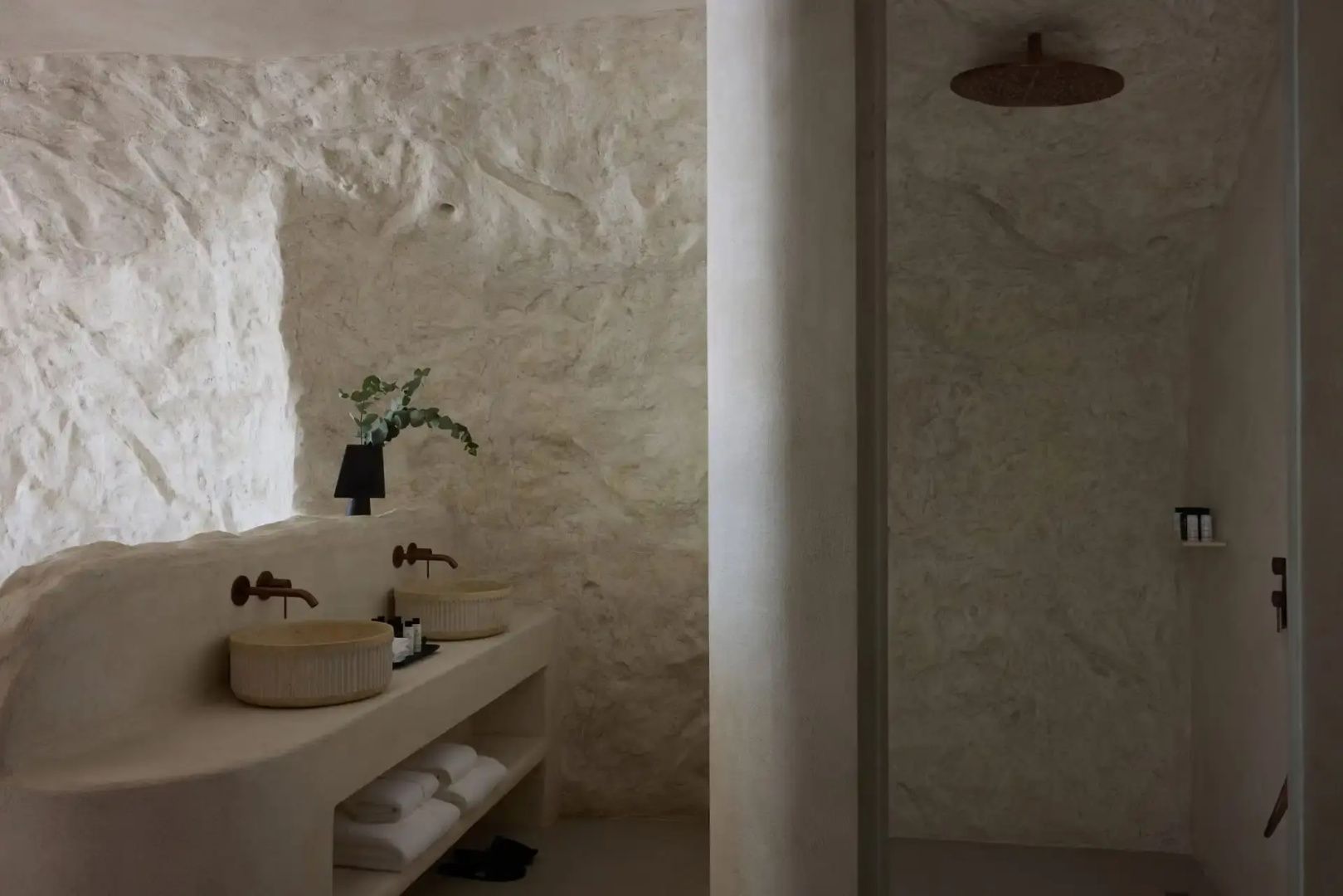 Badezimmer in Naturtönen mit zwei Waschtischen und angrenzender Dusche.