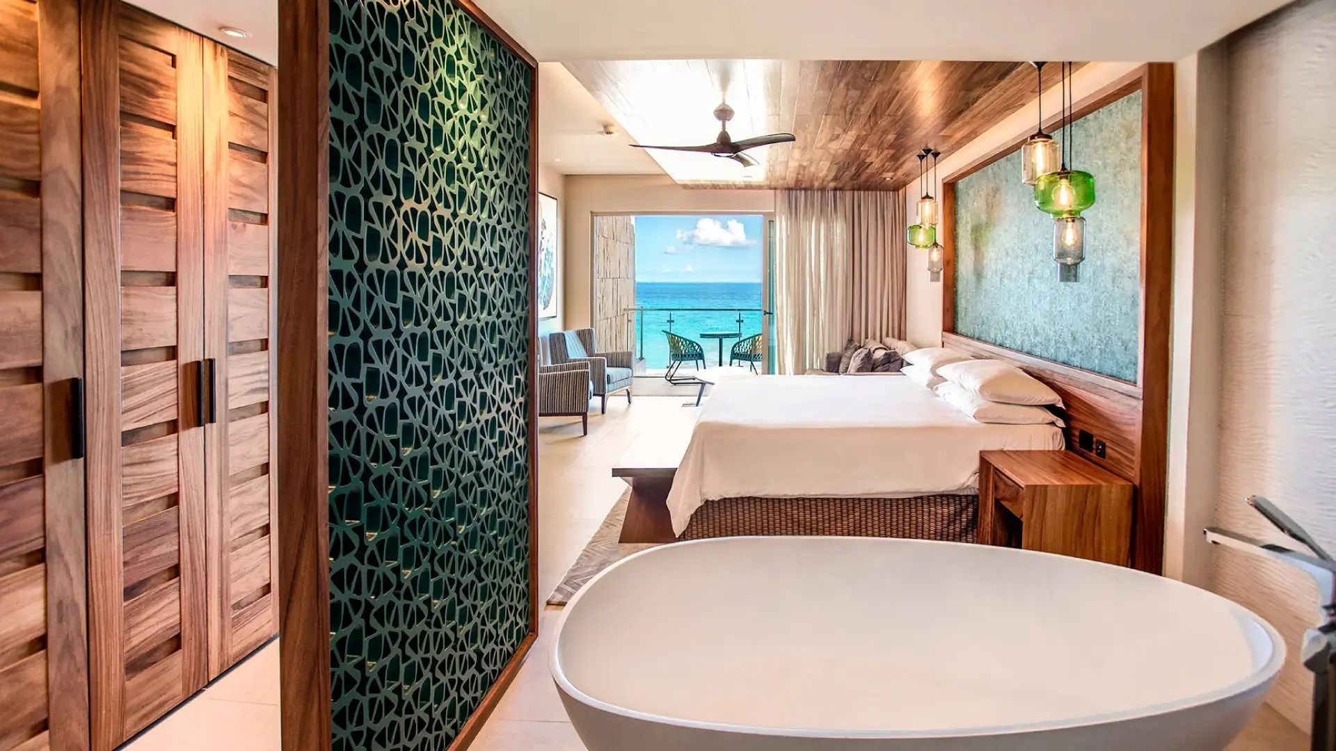 Geräumige Suite mit freistehender Badewanne, großem Doppelbett und Balkon zum Meer.