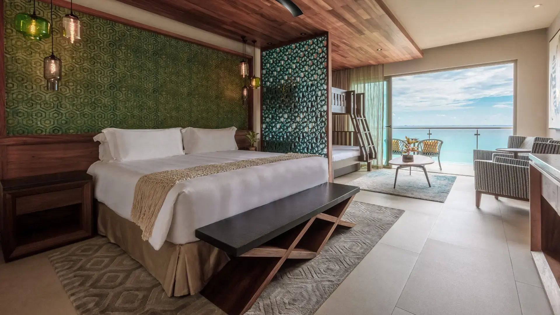 Schlafbereich mit Doppelbett, Holzdecke, Kojenbett und Balkon mit Blick aufs Meer.