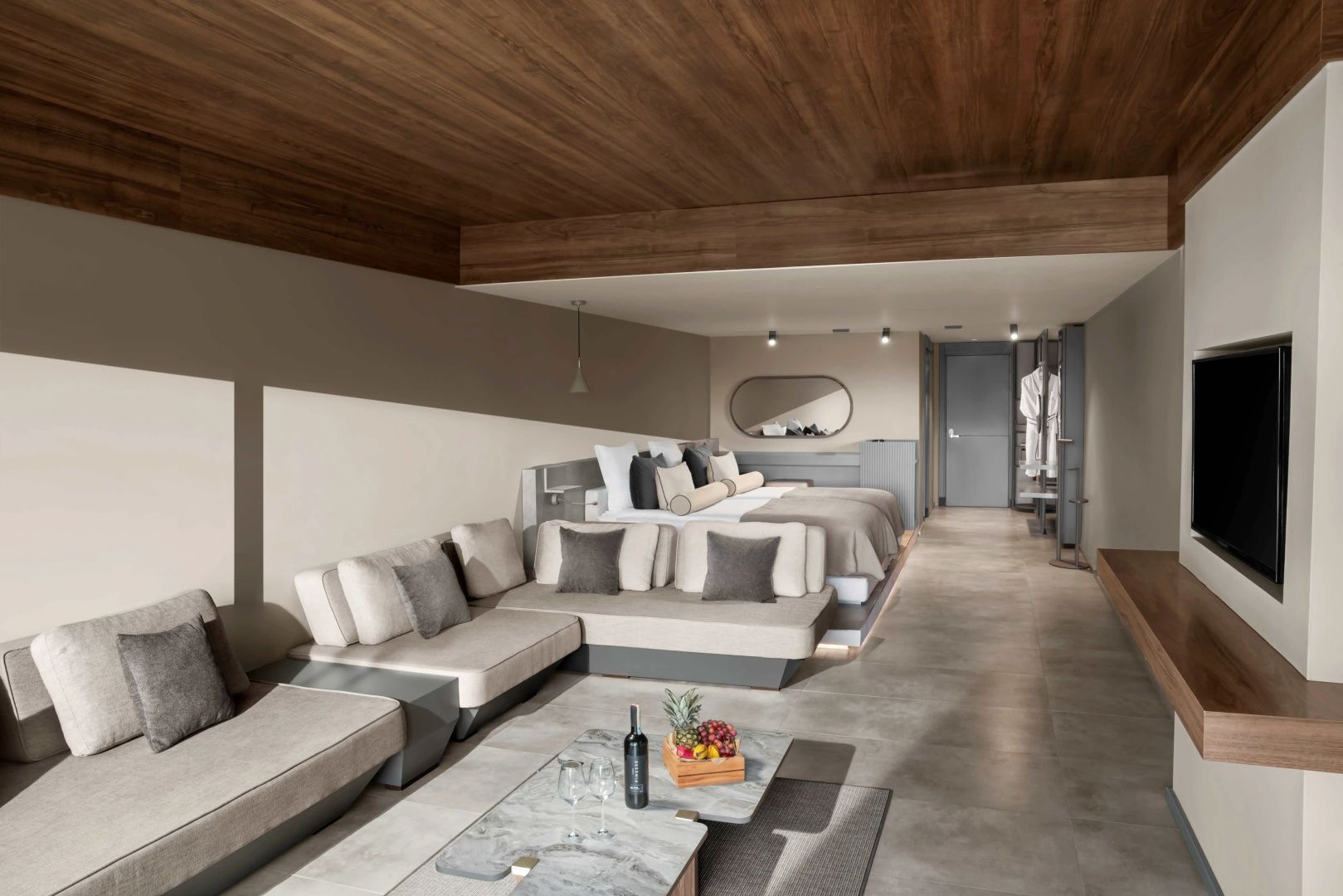 Offener Schlaf- und Wohnbereich mit zwei Betten, Sofa und Holzdecke