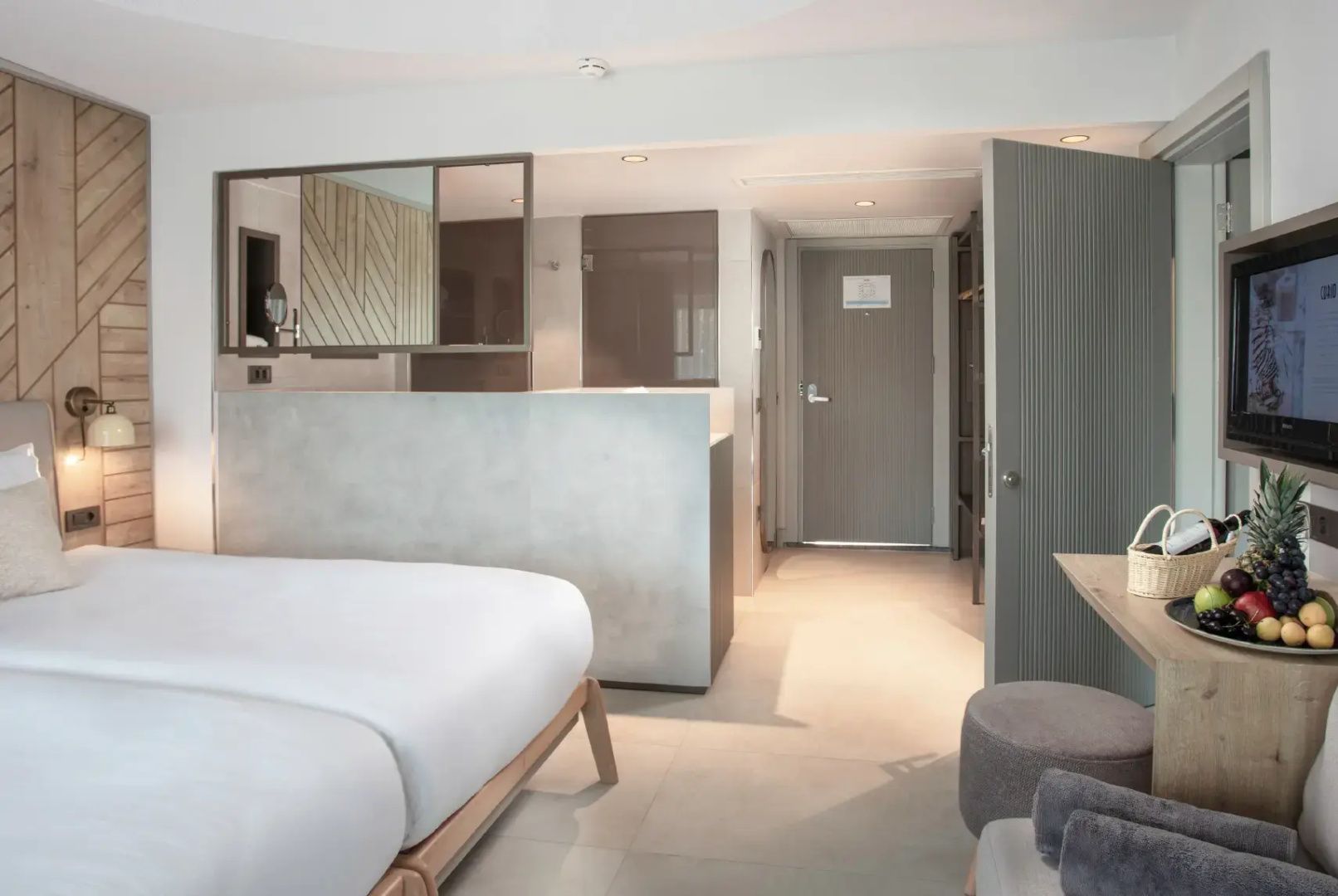Blick vom Schlafbereich eines Hotelzimmers in den Flur und Eingangsbereich.