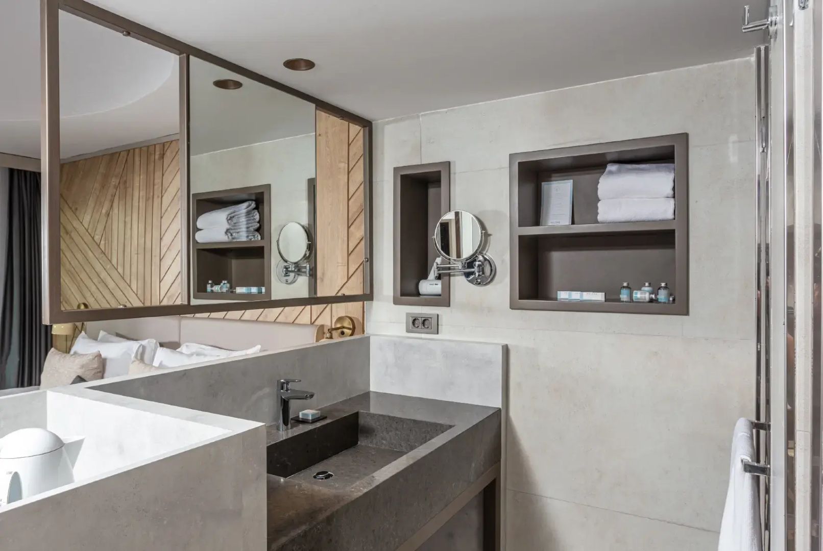 Modernes Badezimmer mit dunklem Waschtisch, großem Spiegel und offenen Wandregalen.