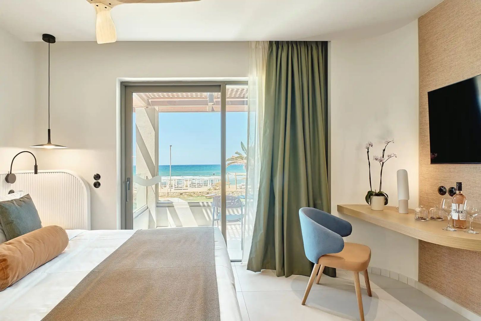 Blick aus dem Hotelzimmer über den Balkon direkt auf den Strand und das blaue Meer.